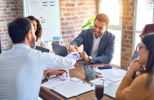Geschäftsleute sitzen gemeinsam am Tisch während eines Businessmeetings