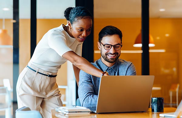 Zwei Geschäftsleute gemeinsam am Laptop im Büro