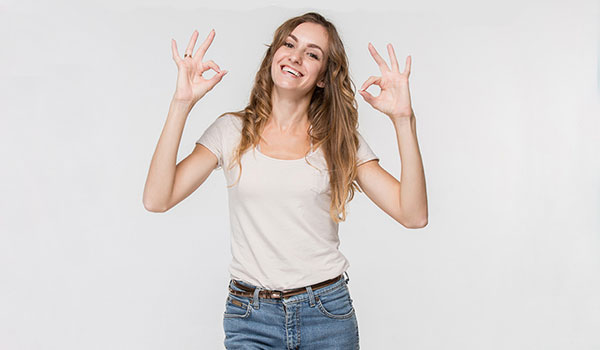 Lächelnde Frau hebt die Hände nach oben